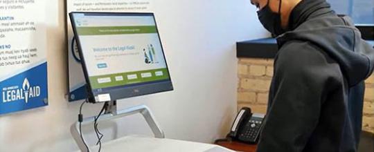 A man in a COVID mask using a legal kiosk